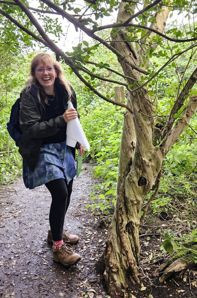 Bethan Prosser (photo by Bela Emerson): woman laughing and standing next to a tree with a paper listening cone
